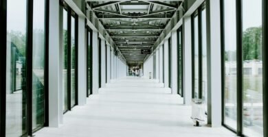 Pasillo moderno con accesos sucesivos que simbolizan niveles verificados para capacidades de IA en ciberseguridad