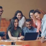 Adultos estudiando tecnología en un aula universitaria para reciclarse profesionalmente ante el avance de la inteligencia artificial