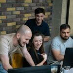 Equipo de desarrollo revisando código y trazabilidad de commits en un portátil