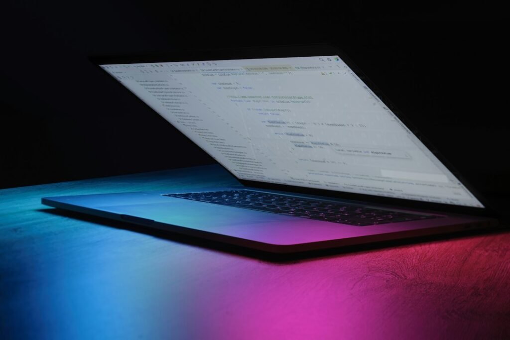 Portátil iluminado con luces de neón, imagen destacada de IA VIRAL y sus 101 prompts para crear contenido