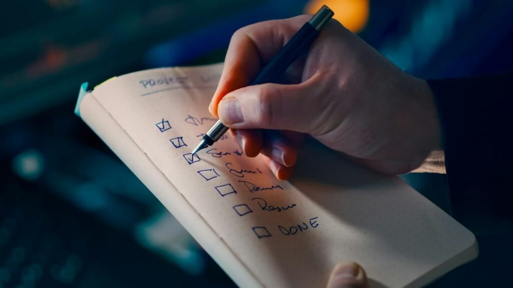 Mano que marca tareas en una lista de comprobación sobre un escritorio, símbolo de evaluación y control de calidad de agentes de inteligencia artificial
