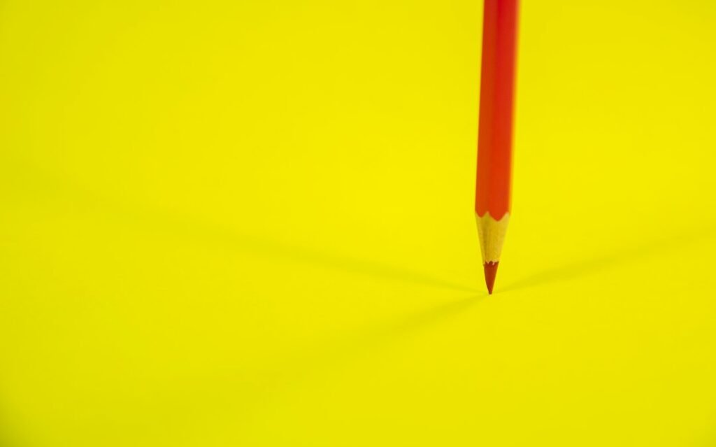 Lápiz rojo sobre un fondo amarillo, imagen ilustrativa de la revisión crítica de documentos con Deep Review y supervisión humana