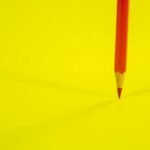 Lápiz rojo sobre un fondo amarillo, imagen ilustrativa de la revisión crítica de documentos con Deep Review y supervisión humana