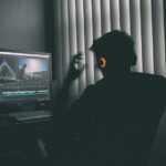 Persona trabajando ante un ordenador para revisar subtítulos automáticos y edición de vídeo con inteligencia artificial