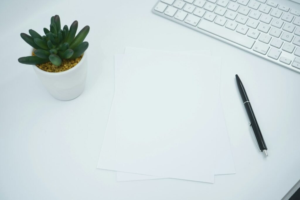 Papeles blancos sobre una mesa junto a un bolígrafo y un teclado, imagen ilustrativa de revisión documental; no es una salida de Nemotron