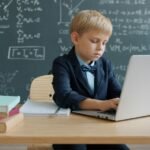 Estudiante usando un portátil en un aula para ilustrar la evaluación de tutores con StudentSim