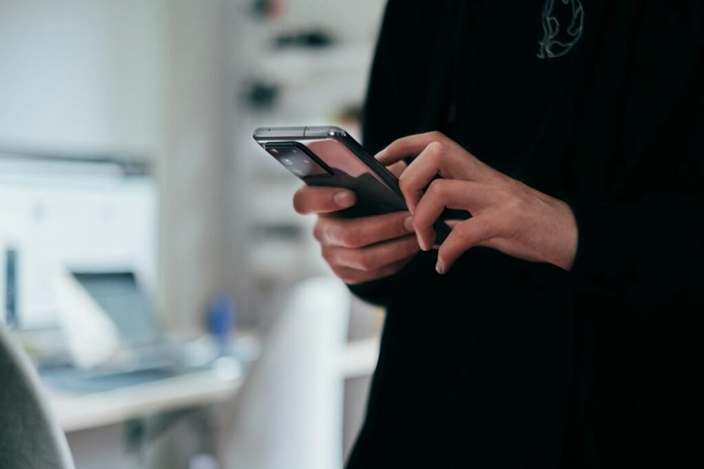 Persona utilizando un teléfono móvil para ilustrar la comprobación independiente de llamadas ante la clonación de voz por inteligencia artificial
