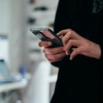 Persona utilizando un teléfono móvil para ilustrar la comprobación independiente de llamadas ante la clonación de voz por inteligencia artificial