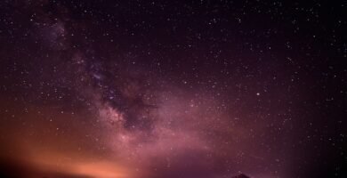 Vía Láctea sobre el paisaje nocturno en tonos púrpura, fotografía ilustrativa del artículo sobre el mapa ultravioleta del cielo creado con Claude Science. No es una imagen del mapa científico.